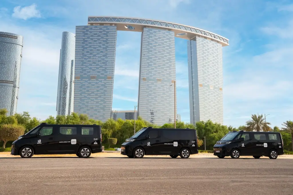Uber and WeRide driverless robotaxi fleet operating in Abu Dhabi with city towers in the background